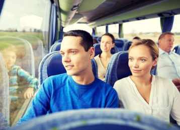 happy couple or passengers in travel bus